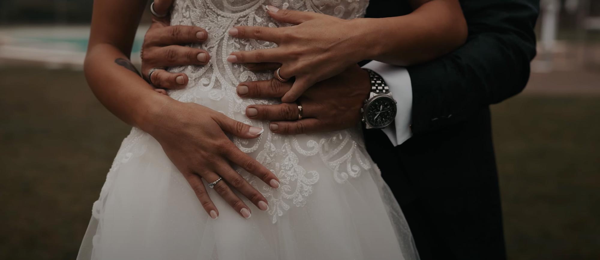 Wedding Video - Dettaglio delle mani dello sposo e della sposa posate sul ventre della sposa, simbolo di amore e complicità