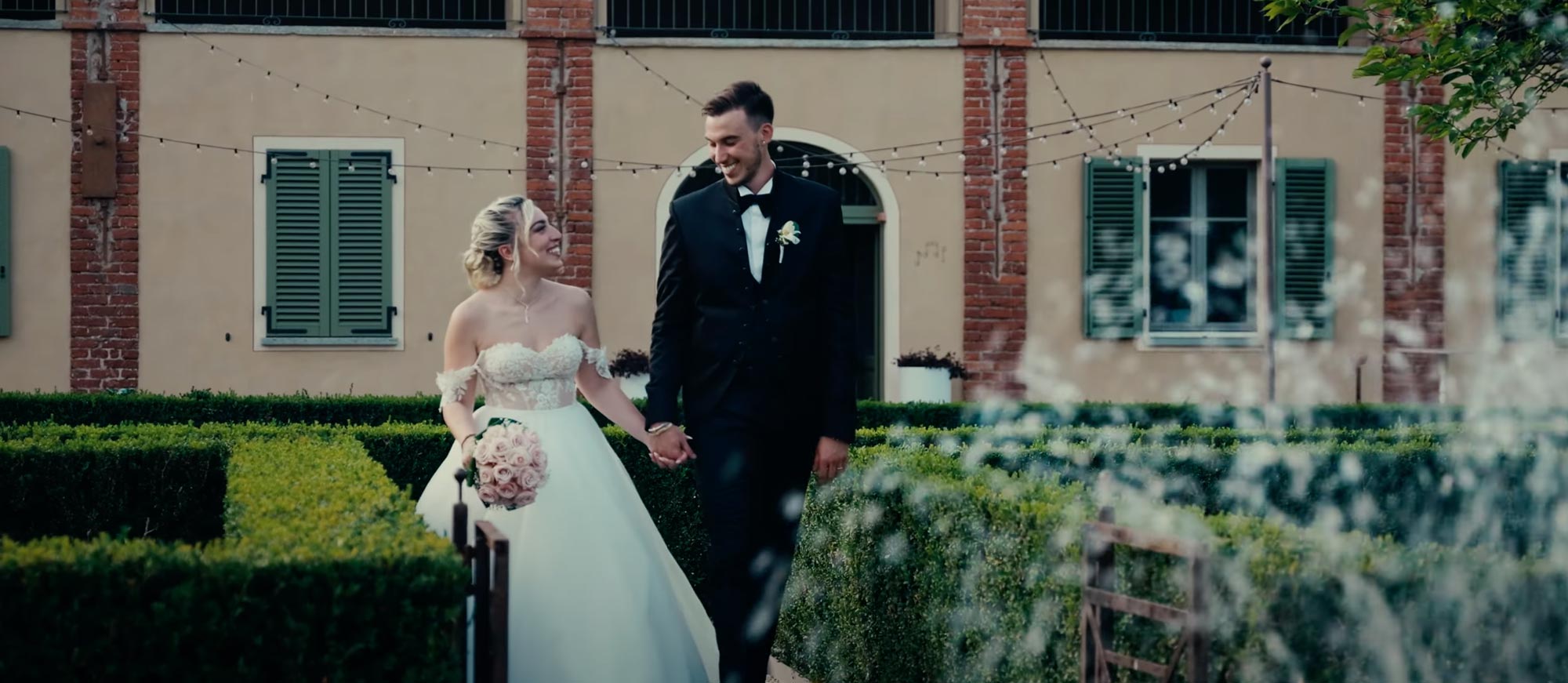 Wedding Video - Sposi che passeggiano mano nella mano in un giardino romantico, circondati dalla natura